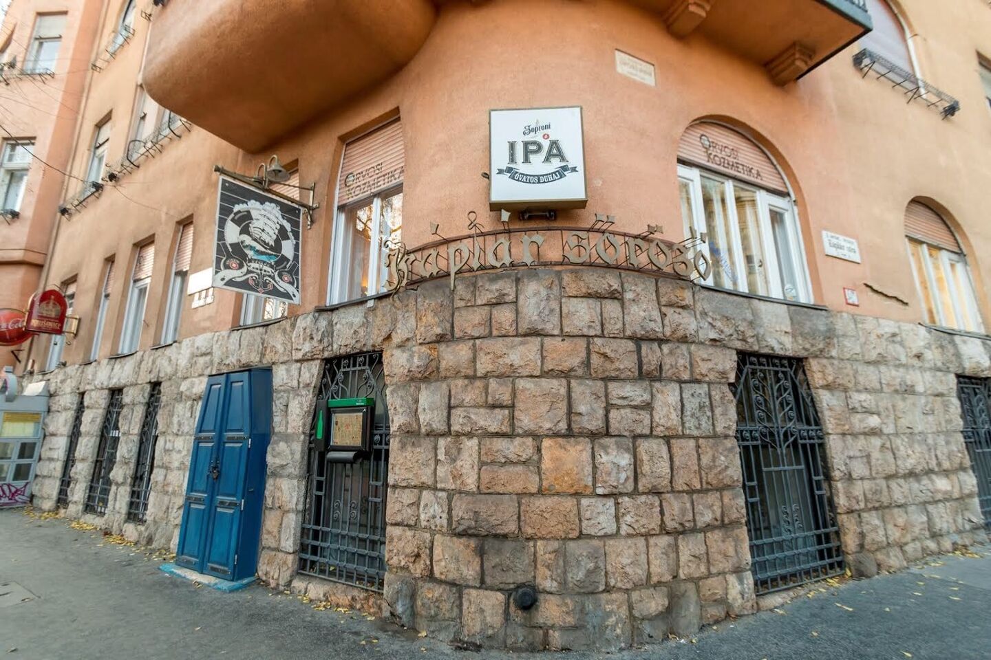 A saroképület kőburkolatos homlokzata a söröző cégérével